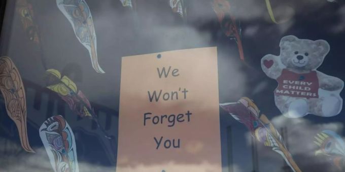 «Wir werden Euch nicht vergessen» steht auf einem Plakat im Fenster einer Schule in British Columbia, nachdem dort die Überreste von 215 Kindern gefunden worden waren. Nun sind in Zentralkanada 751 unmarkierte Gräber entdeckt worden. Foto: Darryl Dyck/The Canadian Press/dpa Indigene Kinder