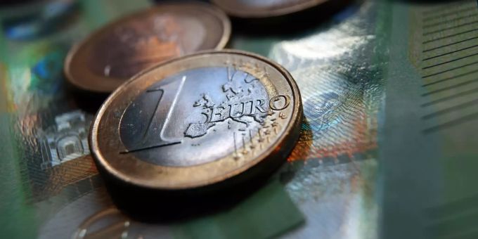 27.05.2021, Bayern, Augsburg: Ein-Euro-Münzen und 100 Euro Banknoten liegen auf einem Tisch. (Symbolbild) Symbolbild - Euro