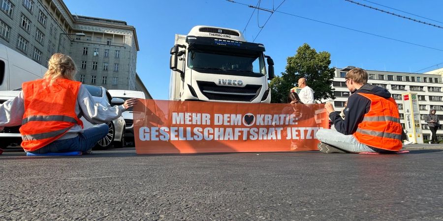 Aktivisten der Gruppe Letzte Generation blockien eine Strasse in Berlin.