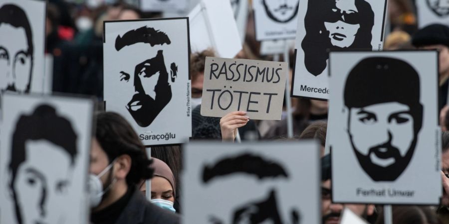 Mit Plakaten und Bildern der Ermordeten erinnern Teilnehmer einer Gedenkveranstaltung an die Opfer des rassistischen Anschlags von Hanau am 19. Februar 2020.