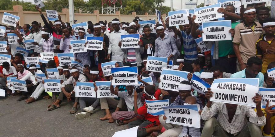 Trauernde tragen Banner mit den Aufschriften «Schwarzer Tag» und «Nieder mit Al-Shabaab» während des Jahrestages einer Explosion in der Hauptstadt von Mogadischu.