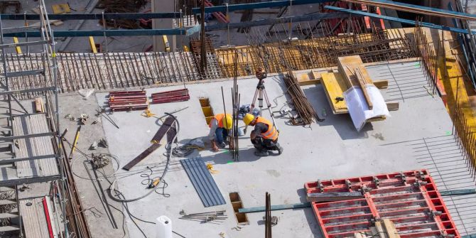 Arbeiter befinden sich auf einer Baustelle.