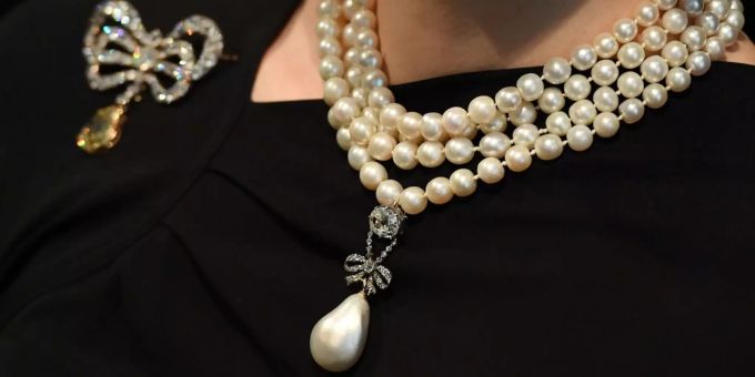 Eine Mitarbeiterin des Auktionshauses Sotheby's trägt denJuwelenanhänger von Marie Antoinette zusammen mit einer Perlenkette. Eine Mitarbeiterin des Auktionshauses Sotheby's trägt denJuwelenanhänger von Marie Antoinette zusammen mit einer Perlenkette.