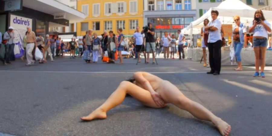 Body and Freedom Festival: Nackte Frau zieht vor Passanten eine künstlerische Pose auf.
