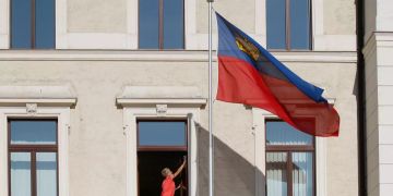 Ein Putzfrau putzt ein Fenster im Regierungsgebäude in Vaduz.