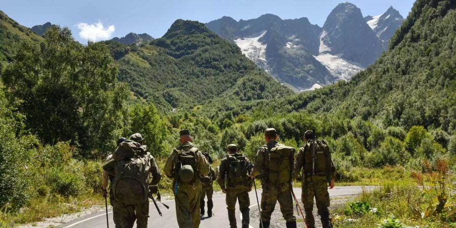 Russische und deutsche Gebirgsjäger auf der gemeinsamen Suche nach Weltkriegsgräbern. Im Hintergrund der Berg Elbrus.