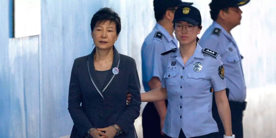 Die ehemalige südkoreanische Präsidentin Park Geun Hye (l.) wird in Handschellen von einer Beamtin zu einem Gerichtstermin im Seoul Central District Court in Seoul (KOR) geführt.