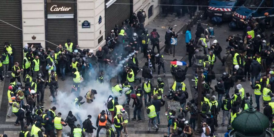 Gelbwesten-Demonstranten treffen auf Sicherheitskräfte in Paris.