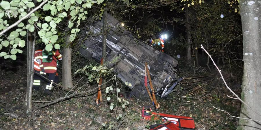 Ein zerstörtes rotes Auto liegt auf dem Rücken in einem Strauch im Wald bei Gretzenbach SO.