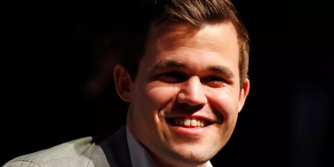 Der amtierende Schachweltmeister Magnus Carlsen freut sich bei der Pressekonferenz über seinen Sieg im Tie-Break.