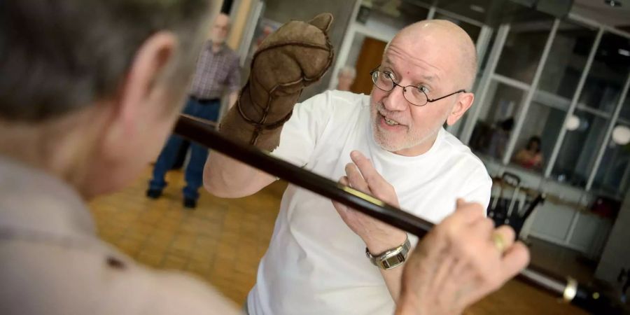 Jan Fitzner (r), Organisator des «Cane Fu» Kurses, zeigt wie man mit einem Krückstock einen Faustschlag abwehren kann.