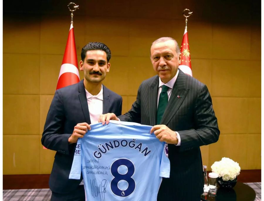 Gündogan übergibt Präsident Erdogan ein signiertes Leibchen.