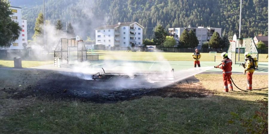 Einsatzkräfte der Feuerwehr löschen den Brand auf dem Schulareal.