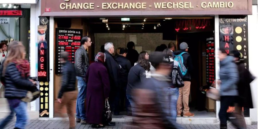 Menschen stehen vor einer Wechselstube in Istanbul Schlange.