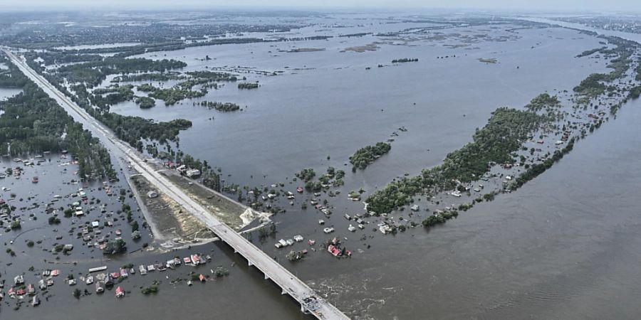 dpatopbilder - In einem überfluteten Dorf in der Nähe von Cherson, stehen Häuser unter Wasser. Die Zerstörung des Kachowka-Damms im Süden der Ukraine entwickelt sich rasch zu einer langfristigen Umweltkatastrophe. Foto: Uncredited/AP