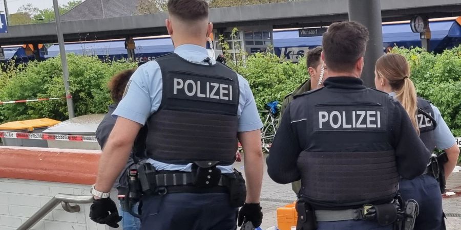 Polizisten stehen am Bahnhof in Wunstorf nach einer Messerattacke.