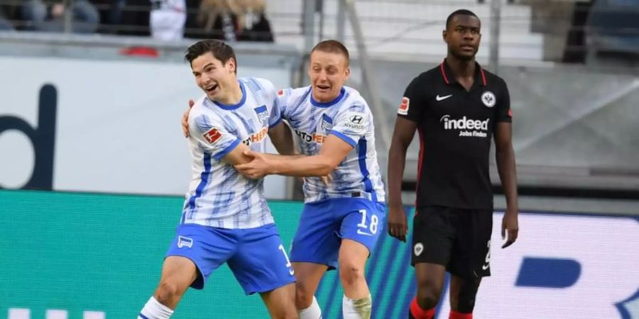 Herthas Torschütze Jürgen Ekkelenkamp (l-r) und Santiago Ascacibar jubeln nach dem Tor zum 2:0 neben Frankfurts Evan Ndicka. Foto: Arne Dedert/dpa