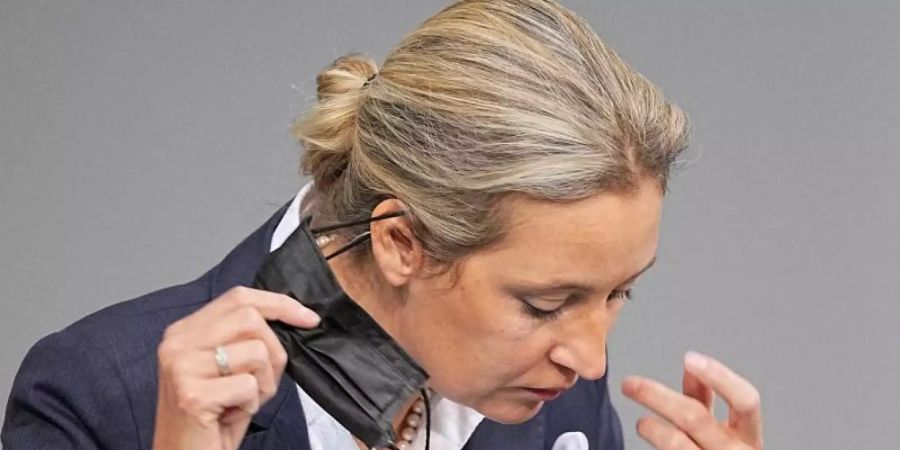 Alice Weidel zieht während einer Sitzung im Bundestag ihre Maske ab. Foto: Michael Kappeler/dpa