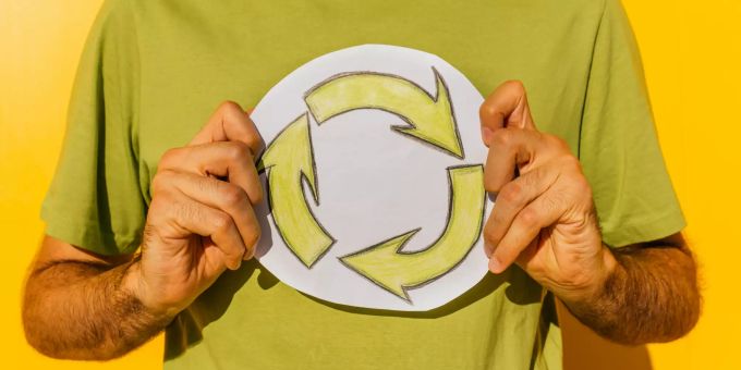 Unterhaltung, Job, Ernährung: Umweltbewusstes und klimaschonendes Verhalten kann viele verschiedene Lebensbereiche berühren. Mann mit einem Symbol in der Hand.