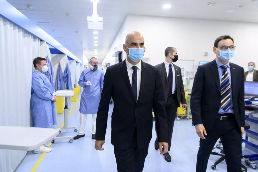 Bundesrat Alain Berset, Mitte, und Raffaele De Rosa, Mitglied des Staatsrates des Kantons Tessin, rechts, gehen während einem Besuch in der Moncucco-Klinik zur Situation der Coronavirus-Pand