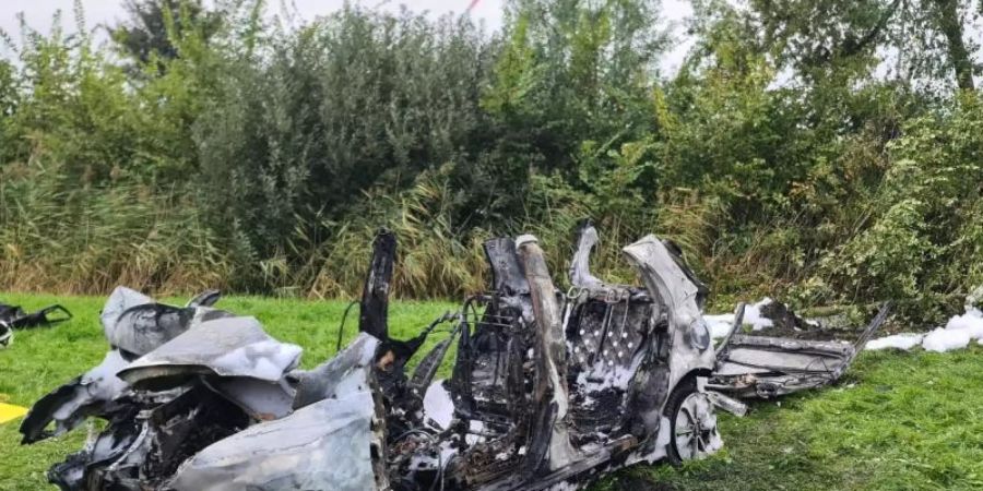 Das ausgebrannte Wrack des Wagens, in dem drei junge Menschen ihr Leben verloren. Foto: Karsten Schröder/Westküsten-News /dpa