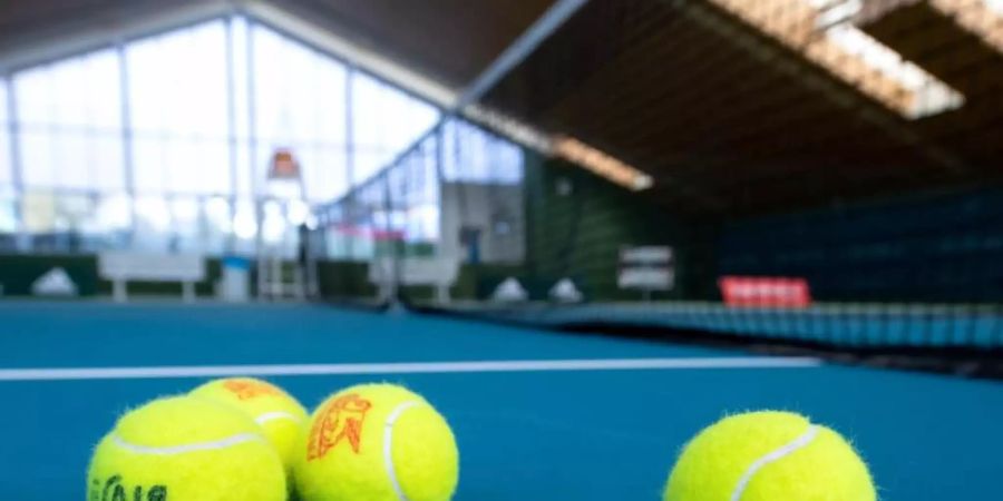Bälle liegen in einer Tennishalle in Bayern auf dem Boden. Foto: Sven Hoppe/dpa