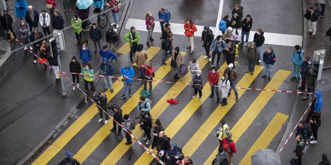 Schaulustige bestaunen die Aktion der Klimaorganisation "Extinction Rebellion" auf der blockierten Strasse in der Zürcher Innenstadt. züri