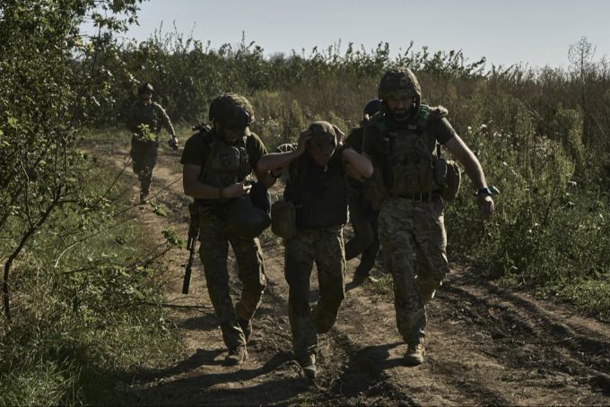 Ukrainische Soldaten helfen einem verwundeten Genossen nahe Bachmuth. ukraine-krieg