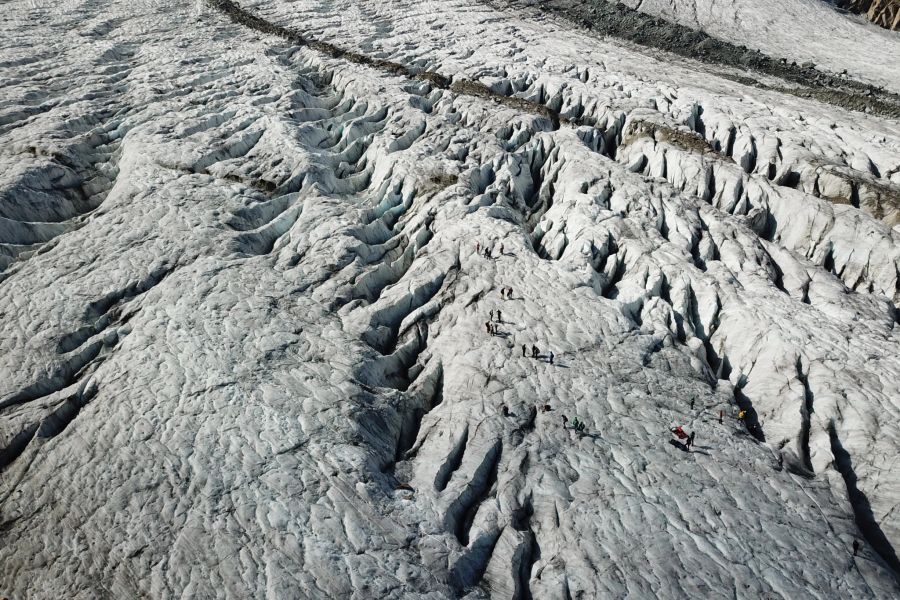 Drohnenaufnahme: Eine Gruppe von Freiwilligen räumt den Persgletscher auf.