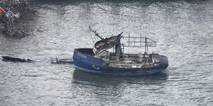 Ausgebranntes Boot im Meer