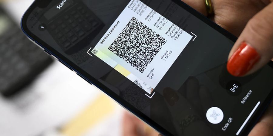 Eine Frau aus Lausanne scannt 2022 mit ihrem Mobiltelefon den QR-Code eines Einzahlungsscheins. (Archivbild)