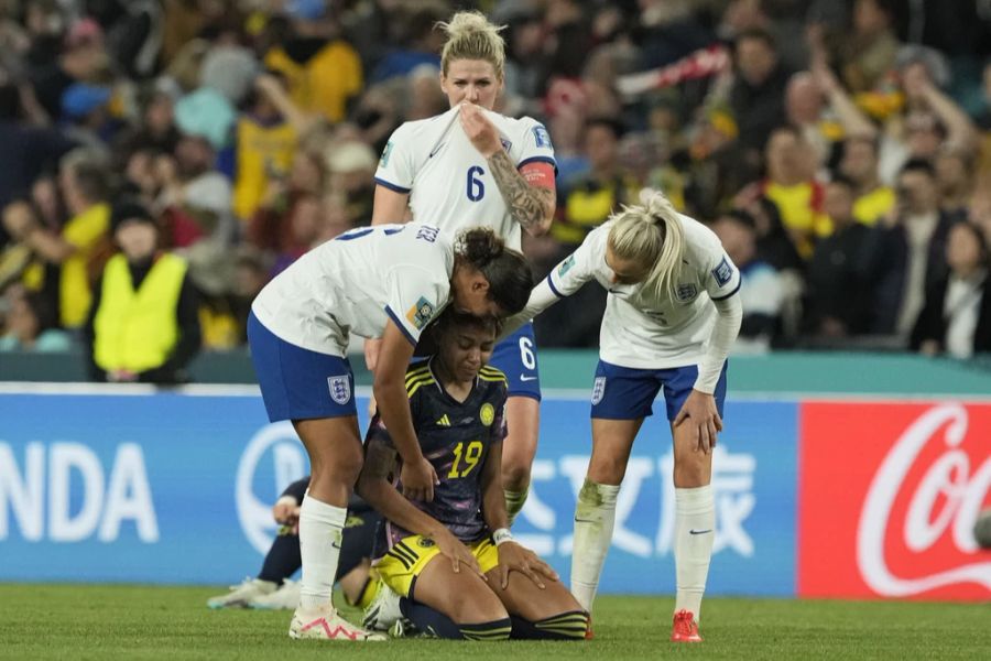 Englands Nationalmannschaft der Frauen trösten Spielerin von Kolumbien.