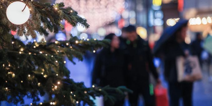 Wer schwierigen Gefühlen an den Weihnachtstagen Platz einräumt anstatt sie zu verdrängen, kann besser mit ihnen umgehen. Strasse Fussgängerzone Tannenbaum Menschen erleuchtet