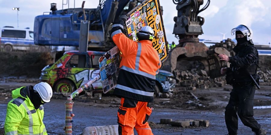 RWE-Mitarbeiter entfernen das Ortsschild des Dorfes Lützerath.