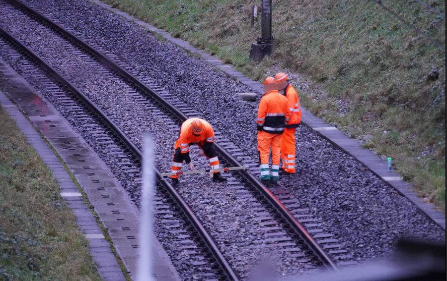 Gleisbau-Experten der SBB messen bei der Schadensstelle.