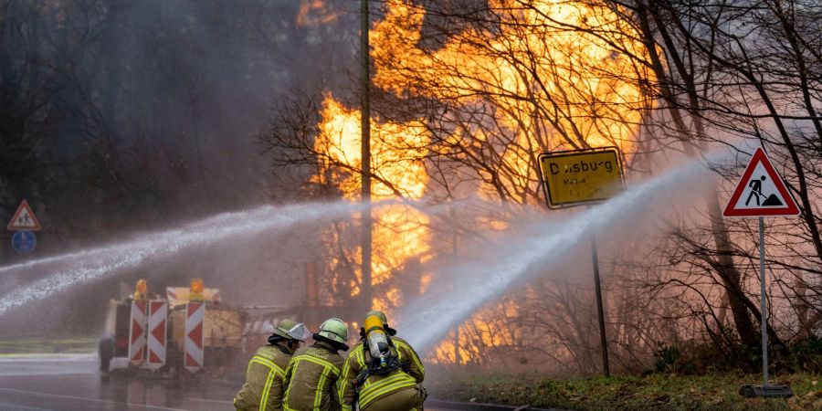 Feuerwehrleute arbeiten daran, ein brennendes Gasleck zu löschen.