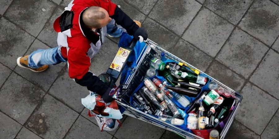 Mann mit Einkaufswagen voller Pfandflaschen in Berlin