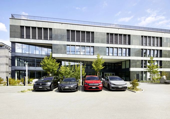 Vier Autos stehen vor einem Gebäude der AMAG. Auto
