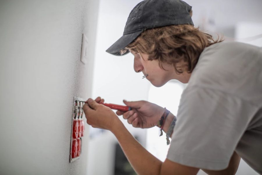 Ein Elektriker in Ausbildung bei der Arbeit.