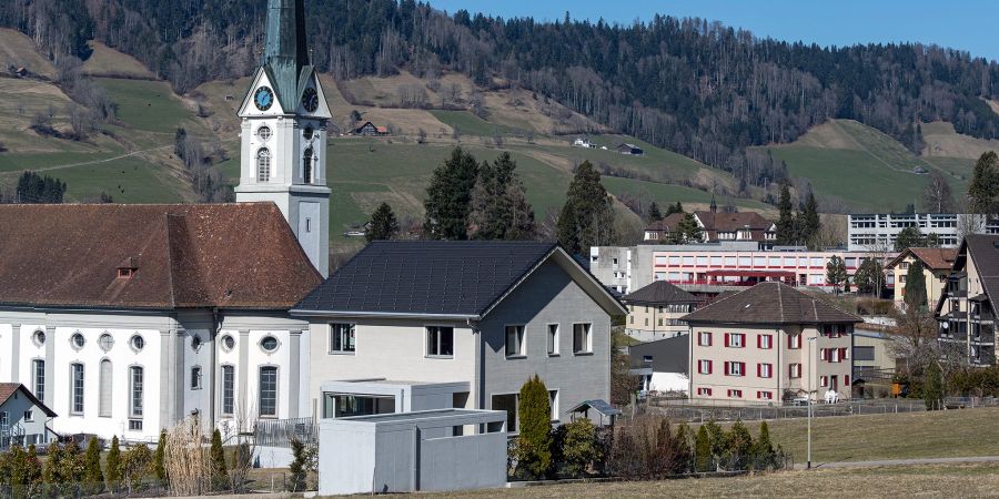 Die katholische Pfarrkirche Johannes und Paulus und rechts hinten die Schulanlage Moosmättili in Schüpfheim.