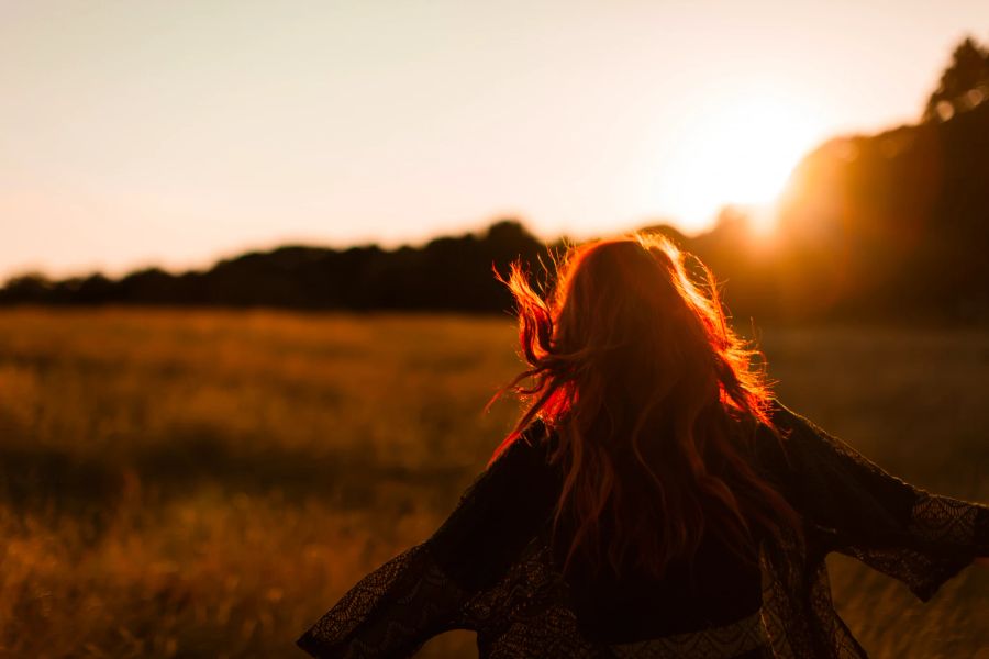 Frau tanzt im Sonnenuntergang