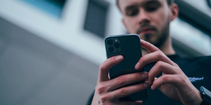 Hass im Internet zu verbreiten ist einfach und ein Zeichen von Schwäche. Mann mit Handy