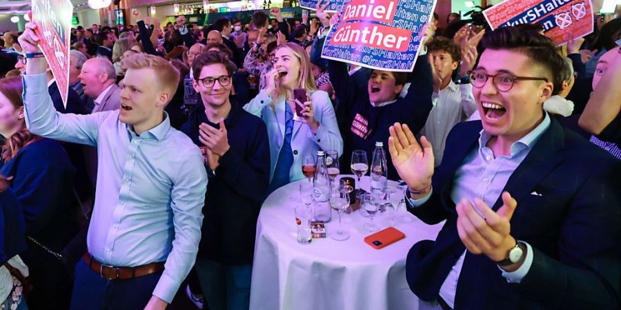 Anhänger und Parteimitglieder der Christdemokraten jubeln auf der Wahlparty nach Bekanntgaben der ersten Prognosen. Im norddeutschen Bundesland Schleswig-Holstein zeichnet sich nach ersten Prognosen ein klarer Sieg der regierenden Christdemokraten ab. Foto: Christian Charisius/dpa