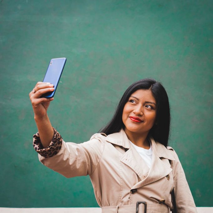 Ein natürliches Lächeln kommt auf Selfies am besten. Frau macht Selfie