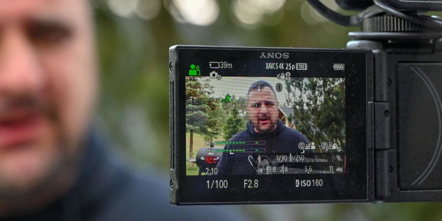 Klaus Glaetzner wird von seiner Frau Melanie für ein neues YouTube-Video am Grill gefilmt.