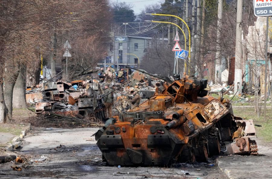 Ukrainische Soldaten untersuchen zerstörte russische Militärfahrzeuge nach einem Gefecht in Butscha. (Archivbild)