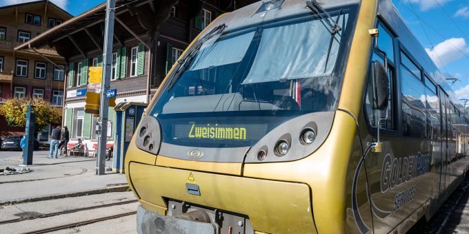 Bahnhof Lenk der Montreux Oberland Bahn mit Regionalzug nach Zweisimmen und Bahnhofplatz an der Lenk im Simmental. Montreux-Oberland-Bahn