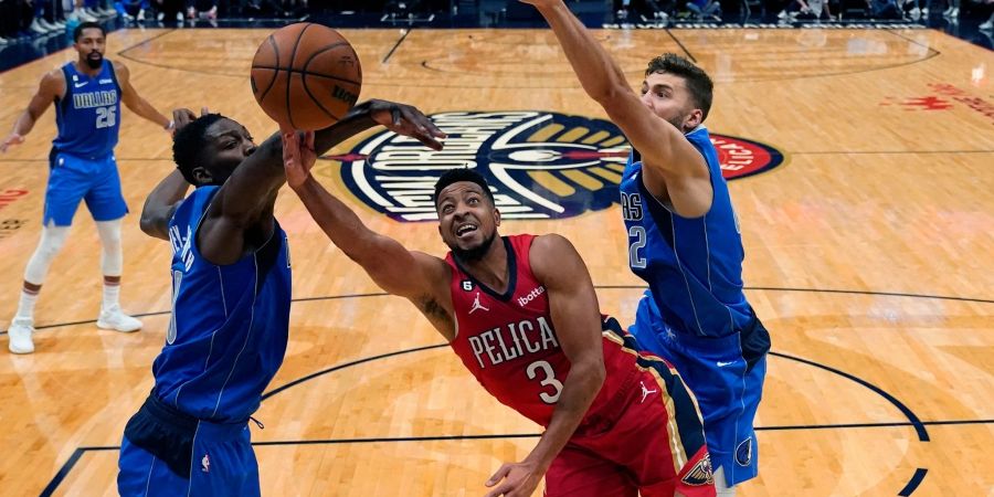 New Orleans Pelicans-Guard CJ McCollum (3) in Aktion mit den Dallas Mavericks-Forwards Dorian Finney-Smith (l) und Maxi Kleber (r).