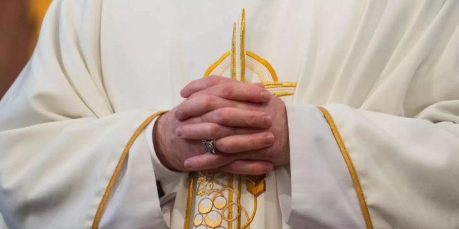 Ein Pfarrer faltet während eines Gottesdienstes die die Hände zusammen. Auch besondere religiöse Feste wie Taufen oder Hochzeiten sowie Trauergottesdienste sollen in kleinem Kreis möglich sein. Foto: Robert Michael/dpa-Zentralbild/dpa