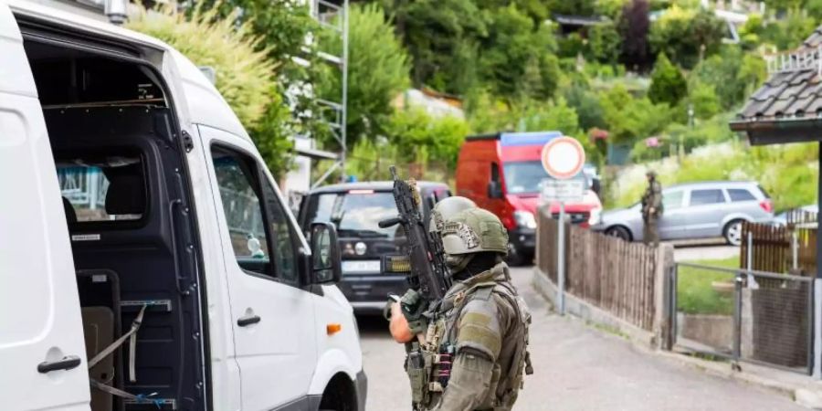 Polizisten des Sondereinsatzkommandos SEK stehen in einem Wohngebiet am Rand der Ortschaft Oppenau. Foto: Philipp von Ditfurth/dpa